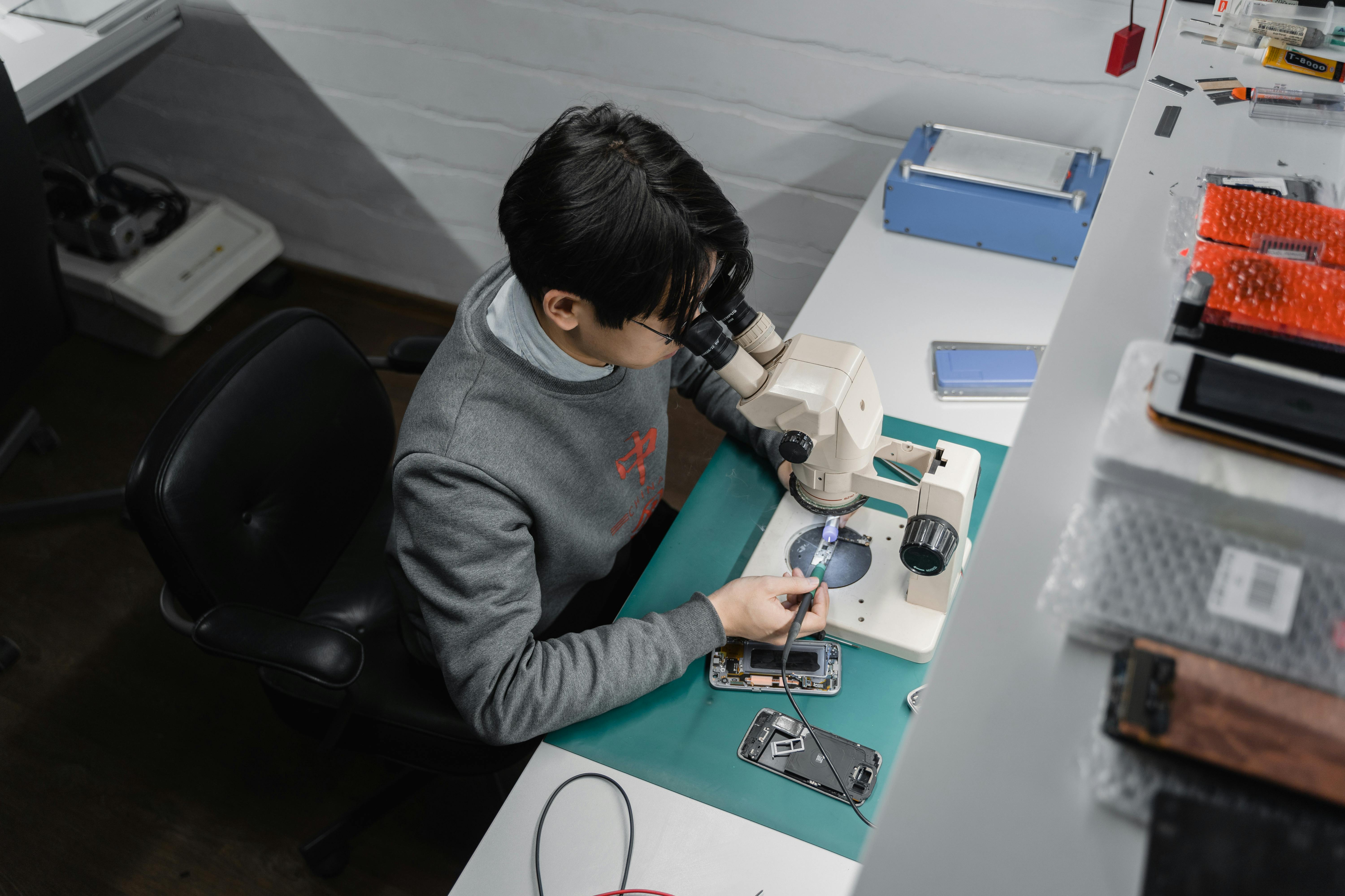 Tecnico reparando un celular en banco de trabajo